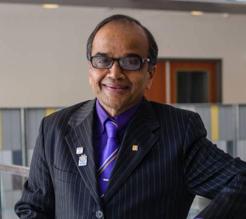 headshot of man with suit and tie, glasses